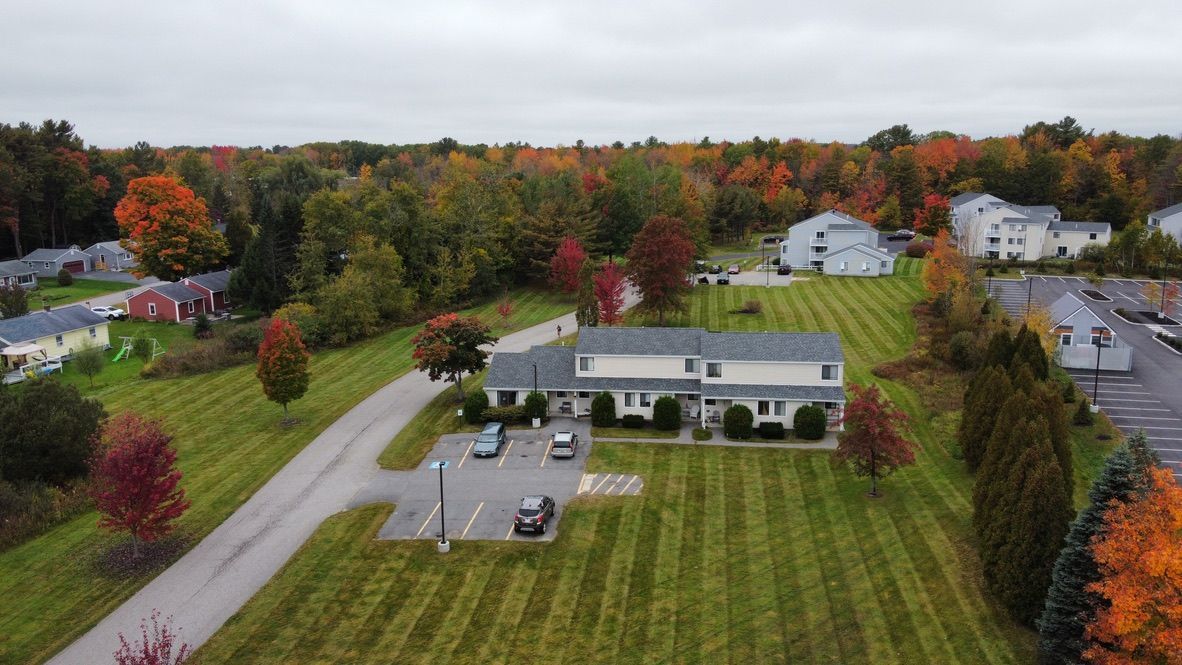 an aerial view of a residential area with houses and trees in the background .