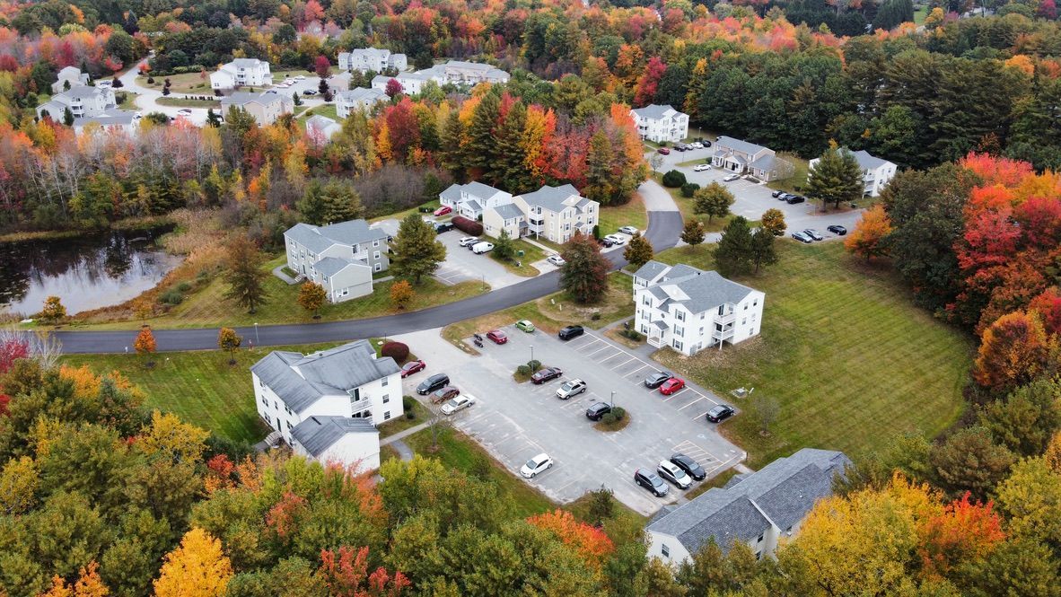 an aerial view of a residential area surrounded by trees in the fall .