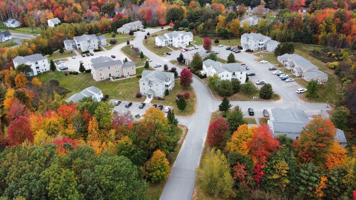 an aerial view of a residential area surrounded by trees in the fall .
