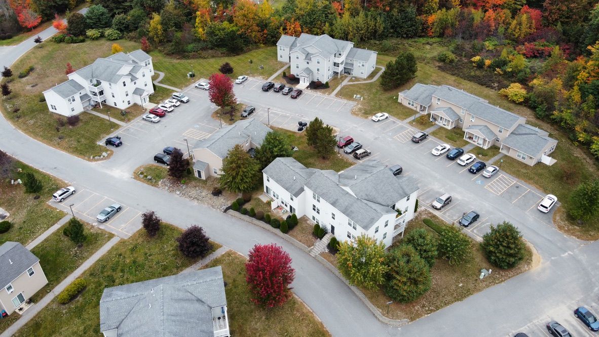 an aerial view of a residential area with houses and a parking lot .