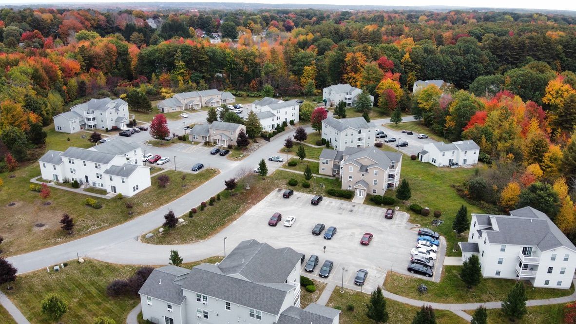 an aerial view of a residential area with trees in the background .