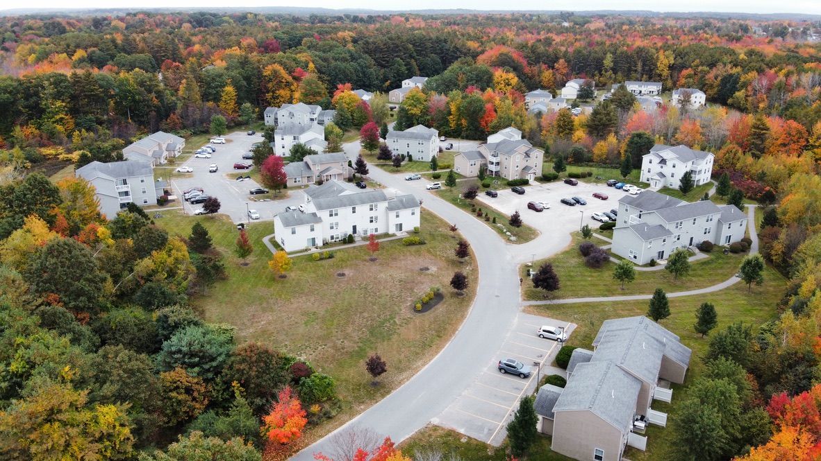 an aerial view of a residential area surrounded by trees in the fall .