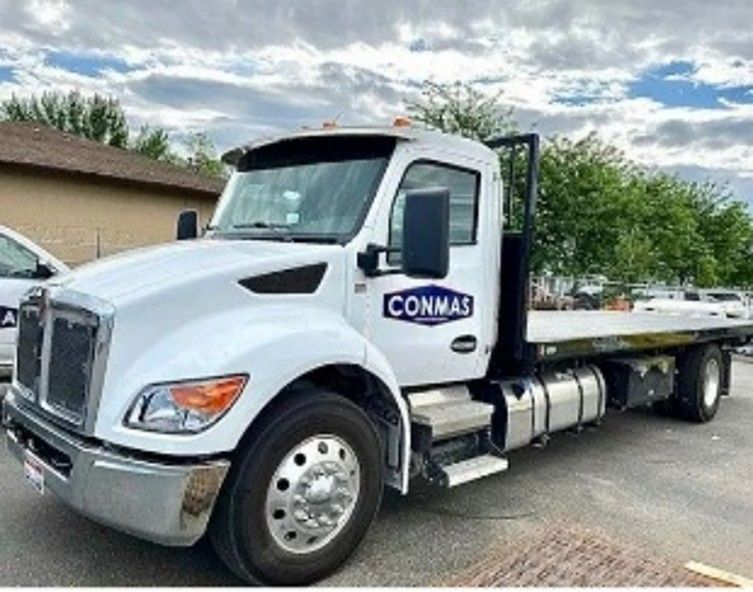 white flatbed tow truck with CONMAS business logo on door. white flatbed tow truck with CONMAS business logo on door.