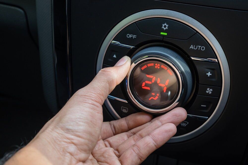 A Person is Adjusting the Temperature of Their Car's Air Conditioner — A Plus Automotive Electrical in Albury, NSW