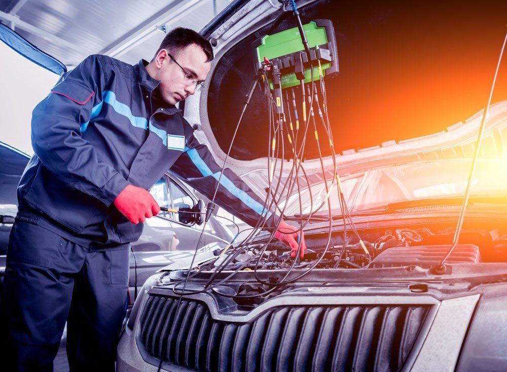 A man is working on the engine of a car in a garage — A Plus Automotive Electrical In Corowa, NSW