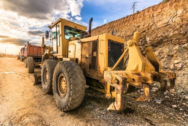 A Yellow Bulldozer is Parked on the Side of a Dirt Road — A Plus Automotive Electrical in Lavington, NSW