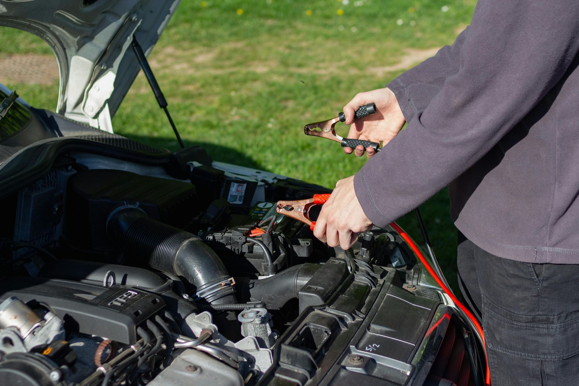 Jumping a car battery with cables.