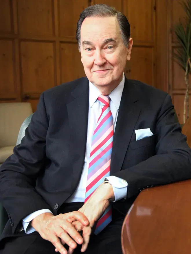 A man in a suit and tie is sitting at a table