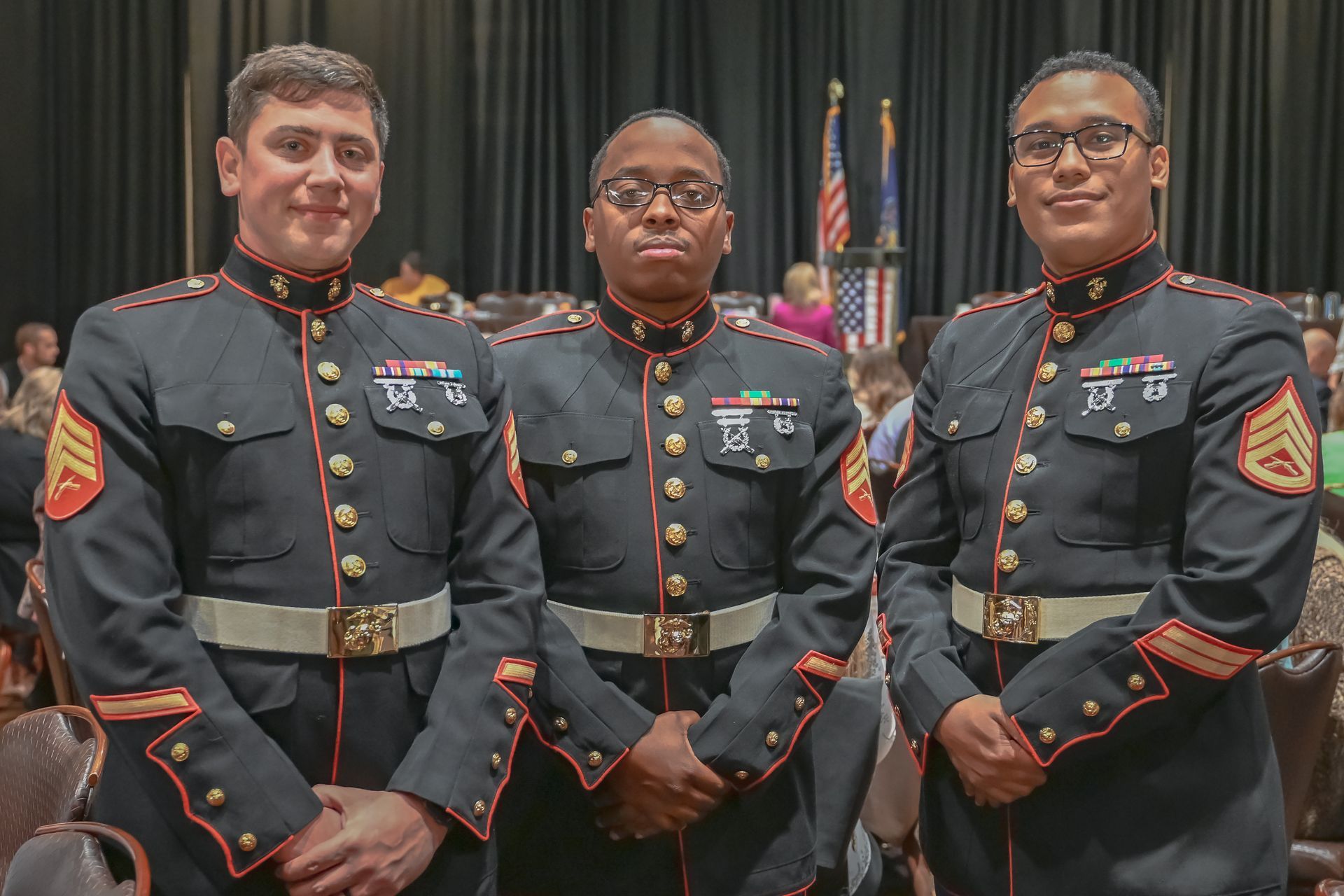 Three young men in military uniforms are posing for a picture.