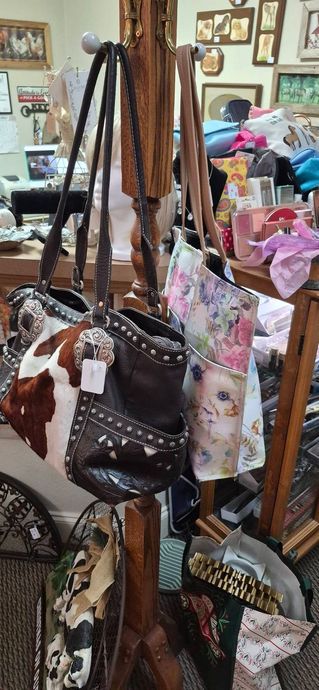 Display of colorful handbags and totes hanging in a shop, with a cluttered boutique background