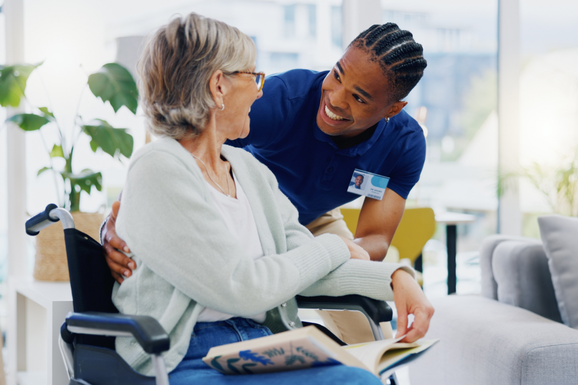 A man is talking to an elderly woman in a wheelchair.