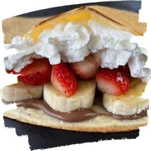 Dessert crepe with banana, strawberries, whipped cream, and chocolate spread
