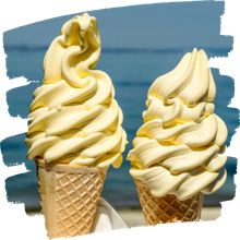 Two vanilla soft-serve cones on waffle cones against a blue sky