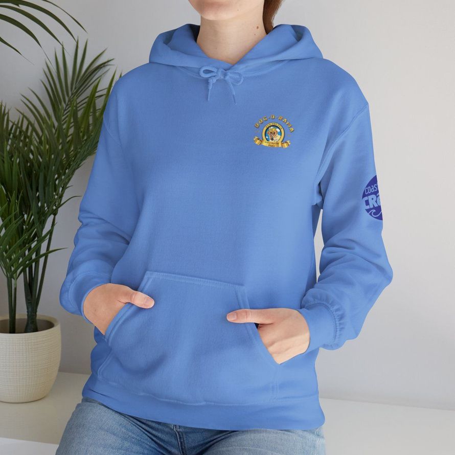 Person in a light blue hoodie with hands in the pockets, standing indoors near a potted plant.