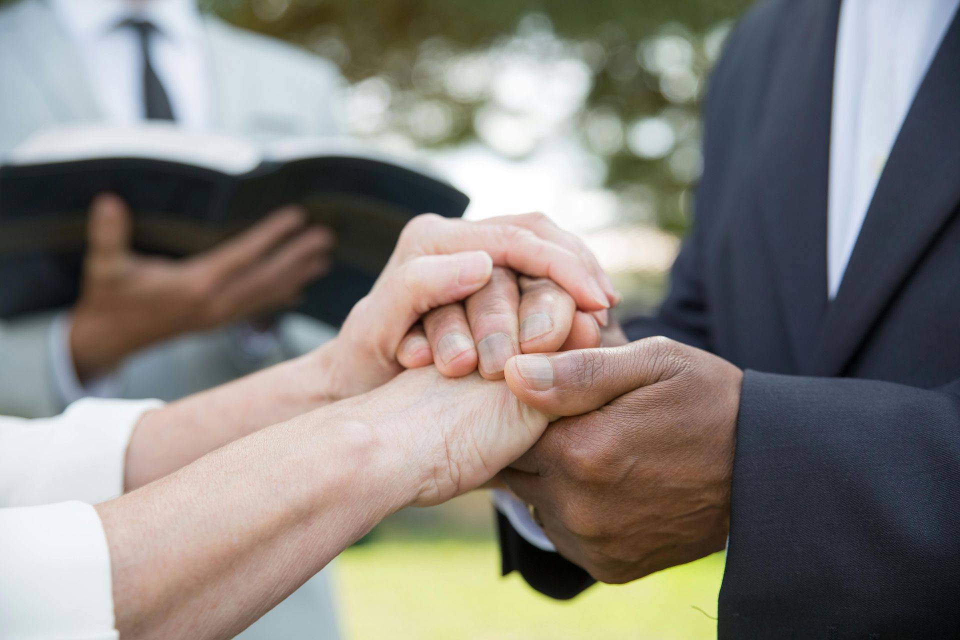 A bride and groom are holding hands during their wedding ceremony.