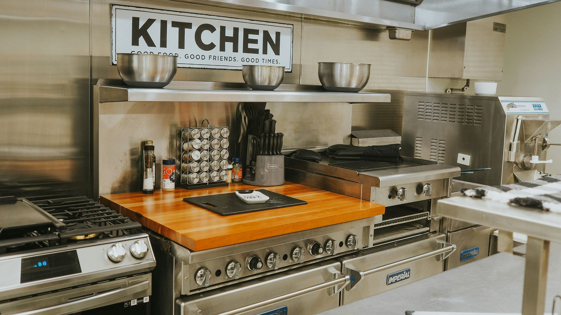 Professional kitchen with stainless steel appliances, bowls, spices, and a