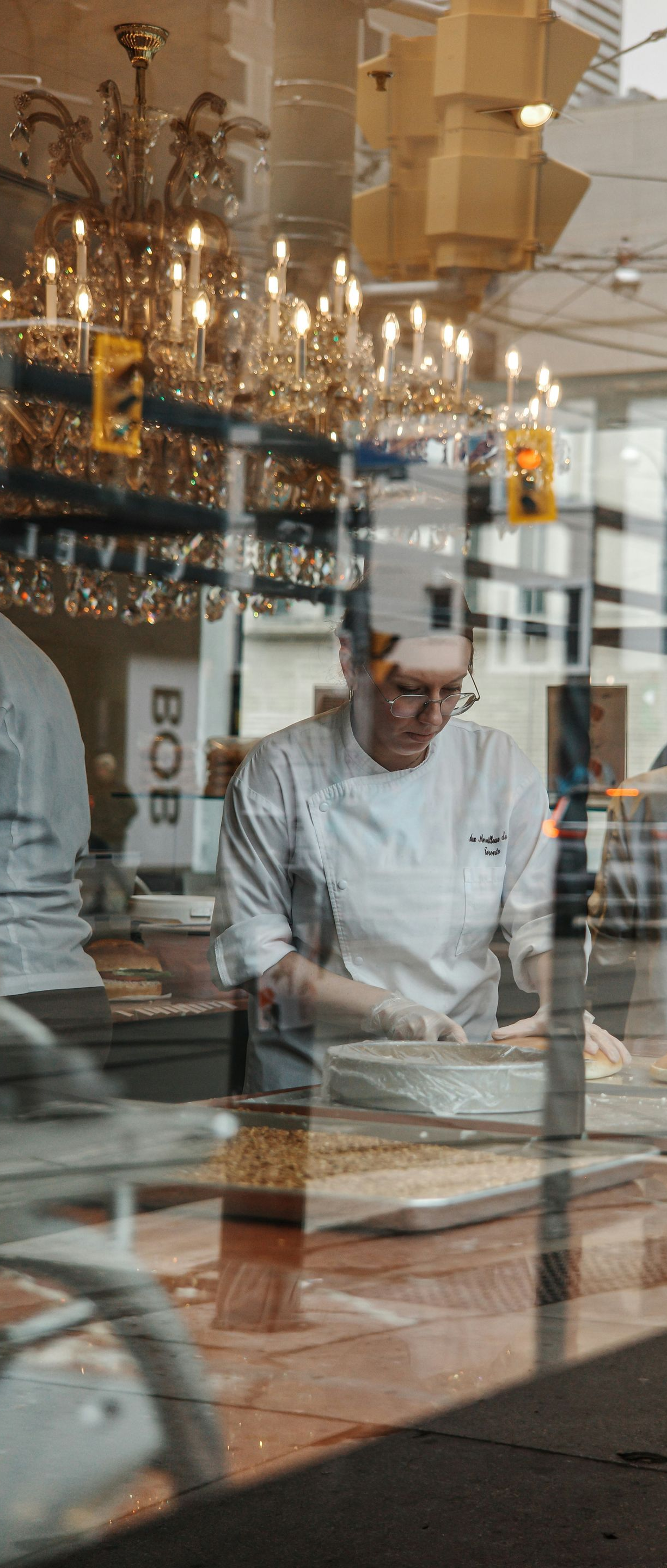Chef preparing food behind a restaurant window display