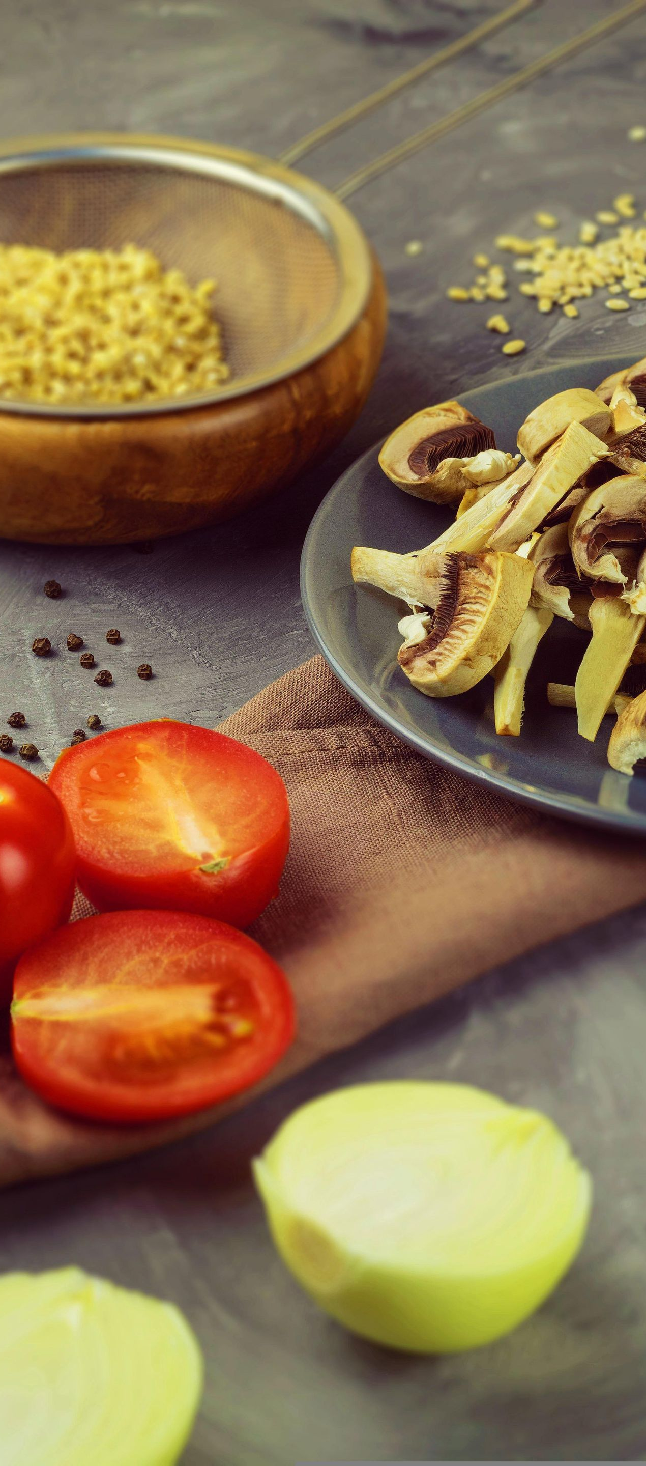 Sliced vegetables and ingredients arranged on a rustic kitchen surface, with a bowl and plate of food prep items