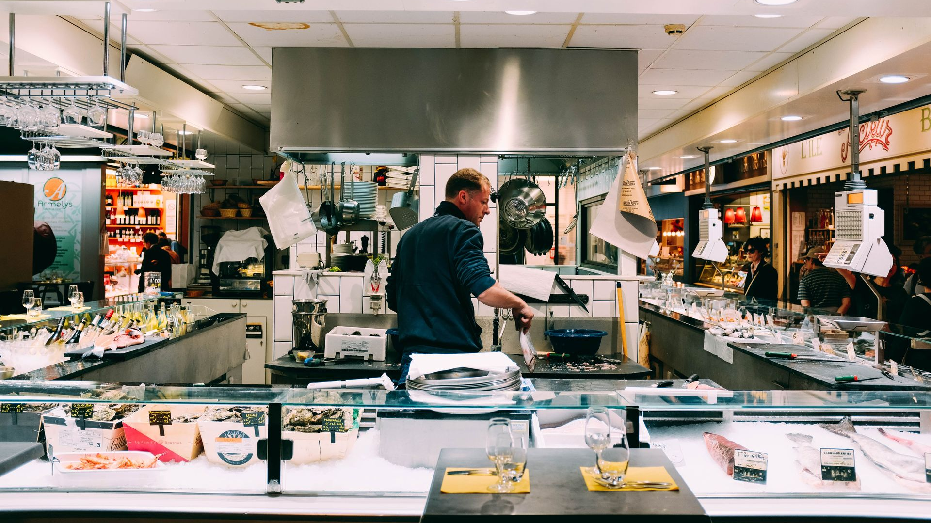 Chef working at a stainless-steel kitchen counter in a bright restaurant kitchen