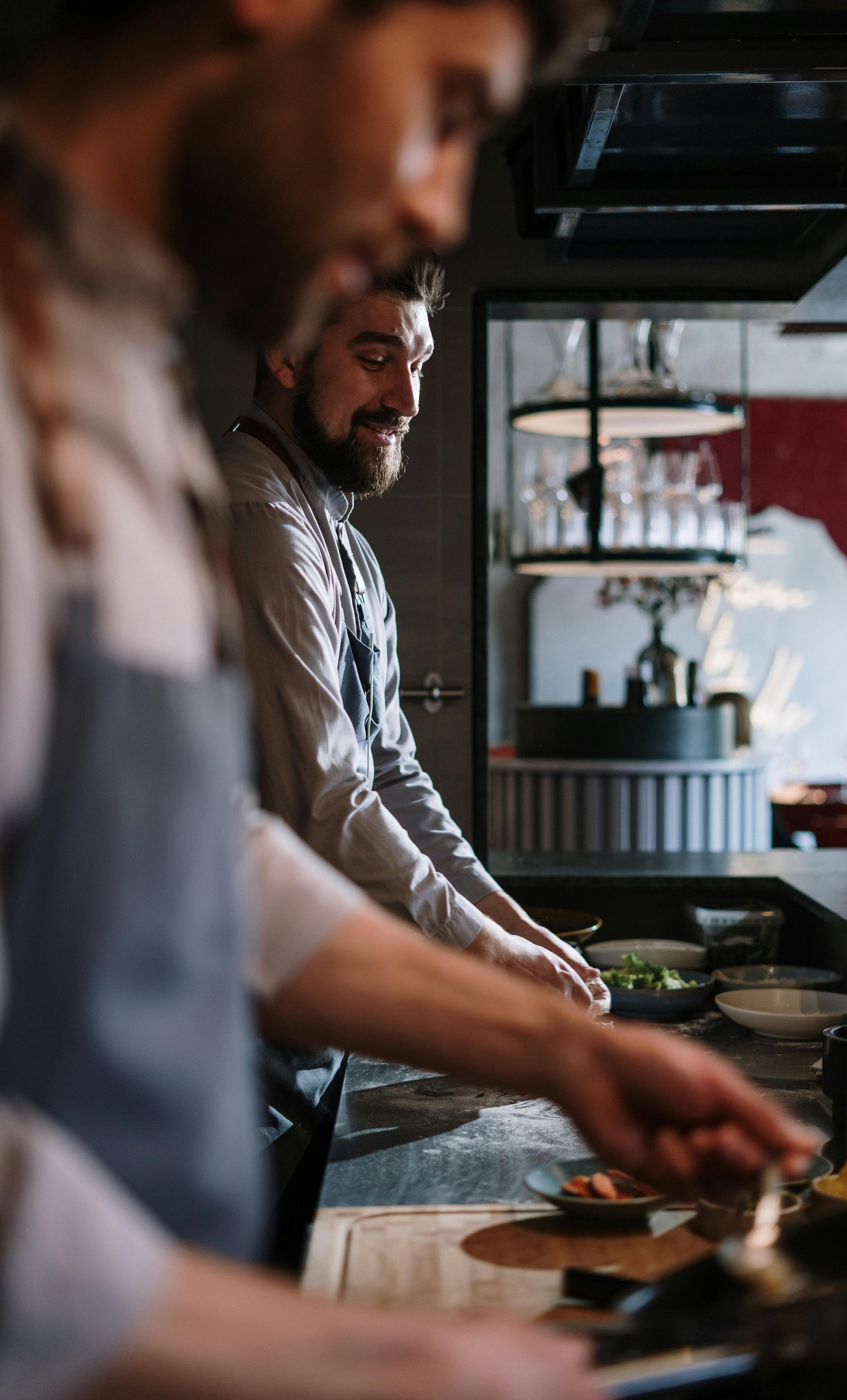 Two chefs preparing food at a kitchen counter in a restaurant