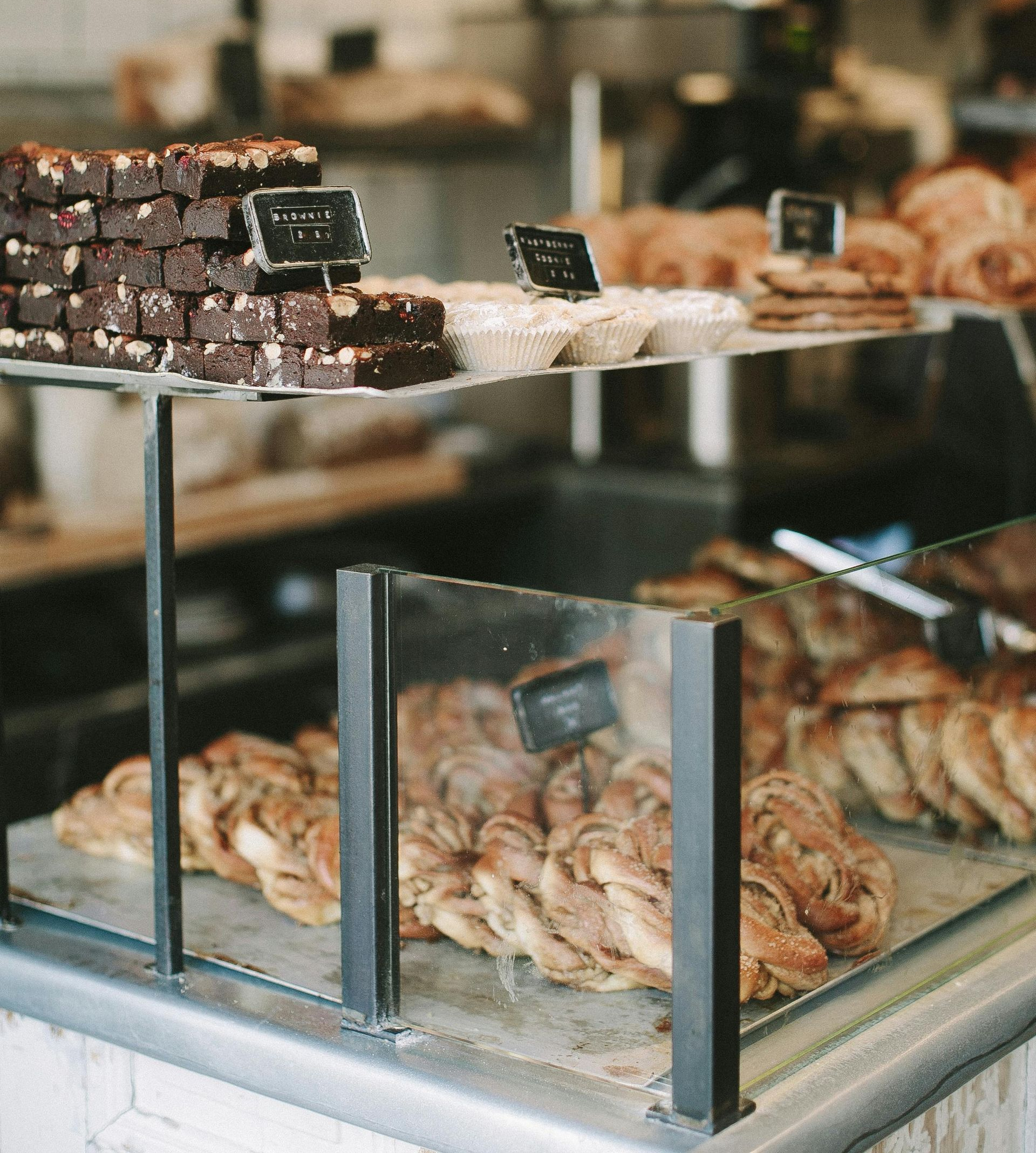 Bakery display case with assorted pastries, including brownies and braided bread.