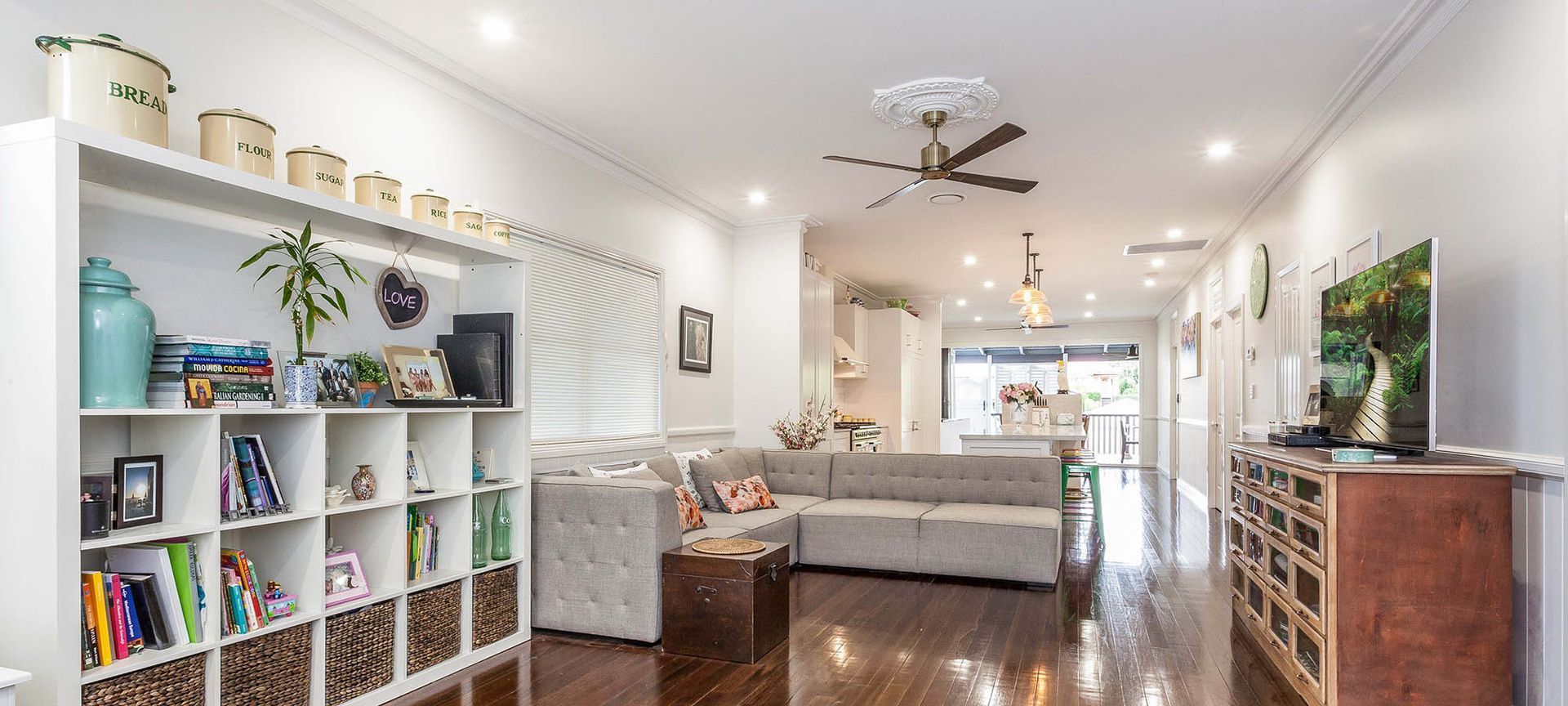 Spacious living room with built-in shelves, sectional sofa, and a wooden chest of drawers.