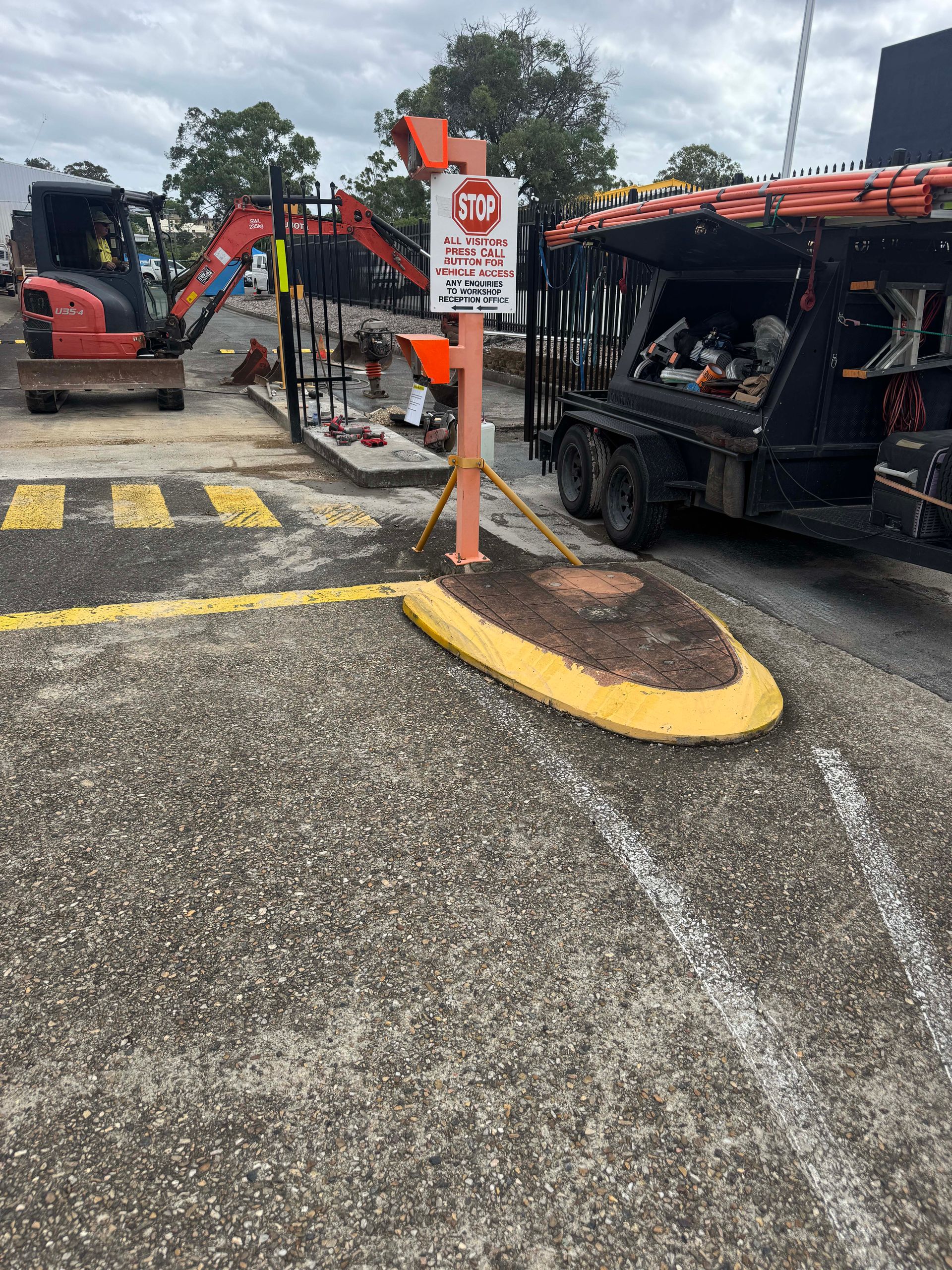 Construction site with a stop sign. Yellow pedestrian crossing, heavy machinery, a utility truck, and road work.