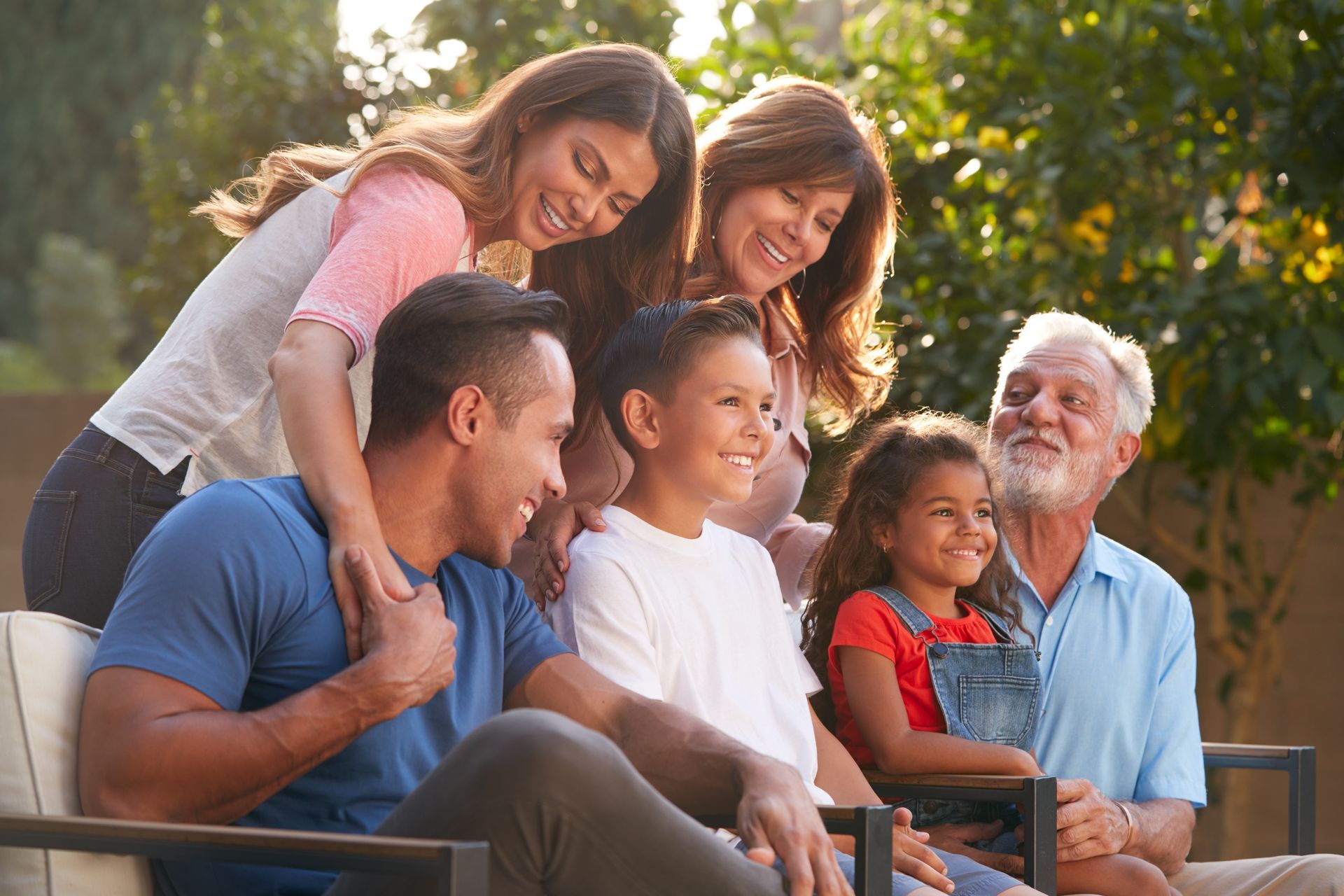 Family smiling together outdoors on a patio at sunset