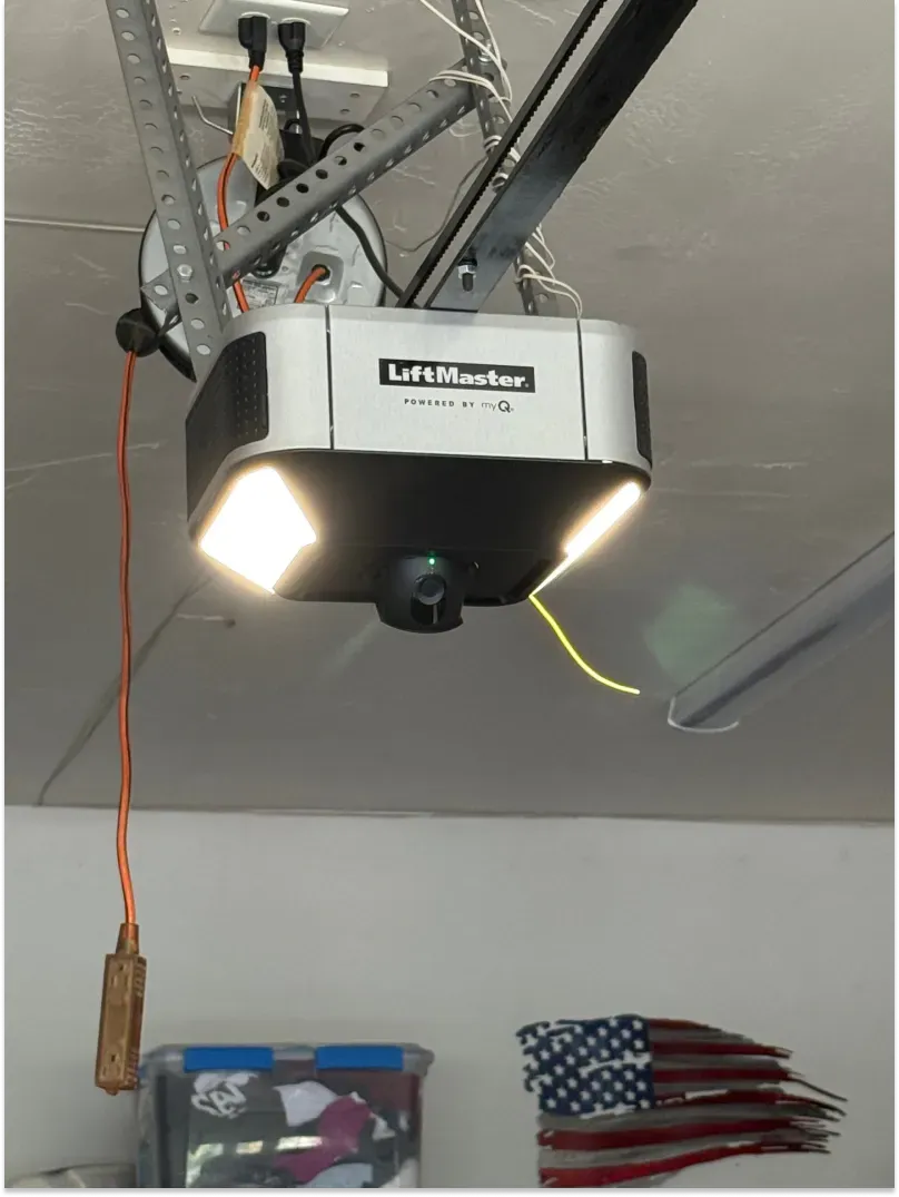 Garage door opener mounted on ceiling with light.