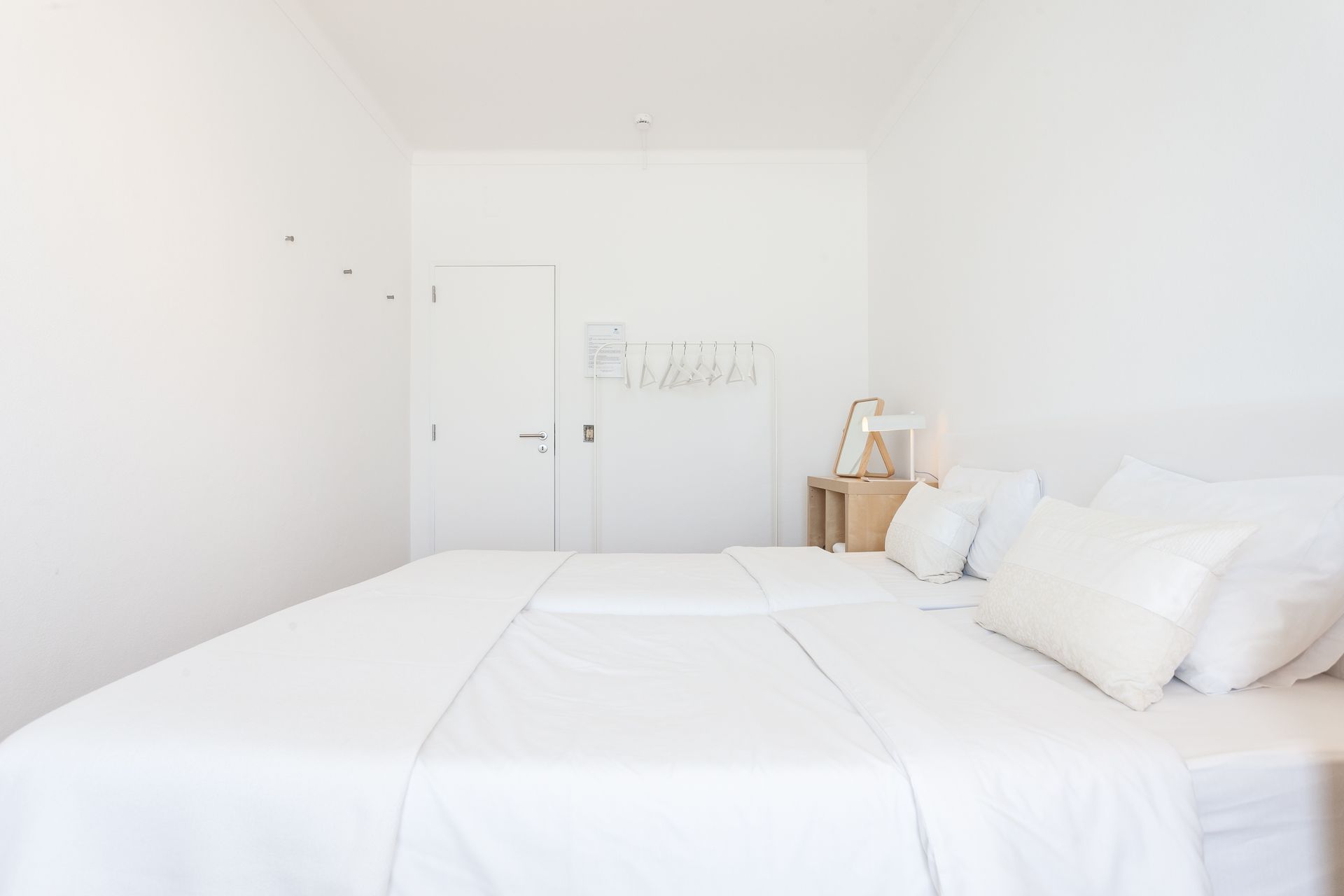 a bedroom with two beds and white sheets and pillows .