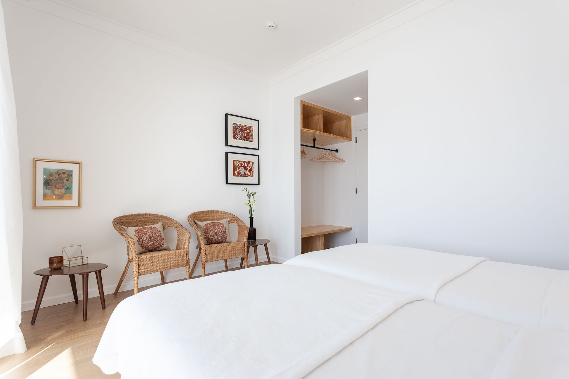 a bedroom with two beds , two chairs and two tables .