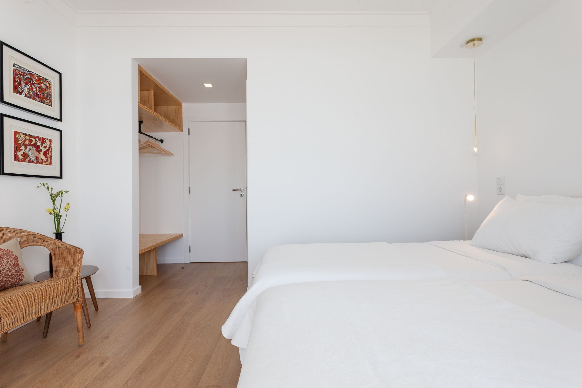 a bedroom with two beds , a chair and a wicker chair .