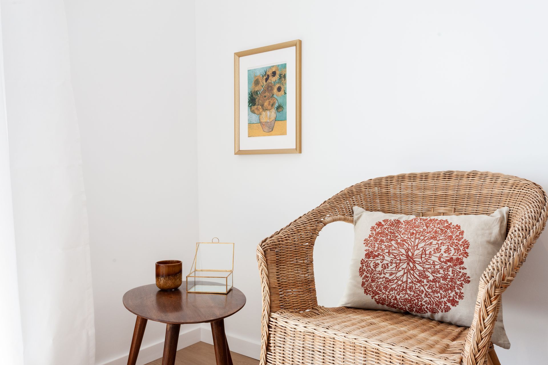 a wicker chair is sitting in a corner of a room next to a table .