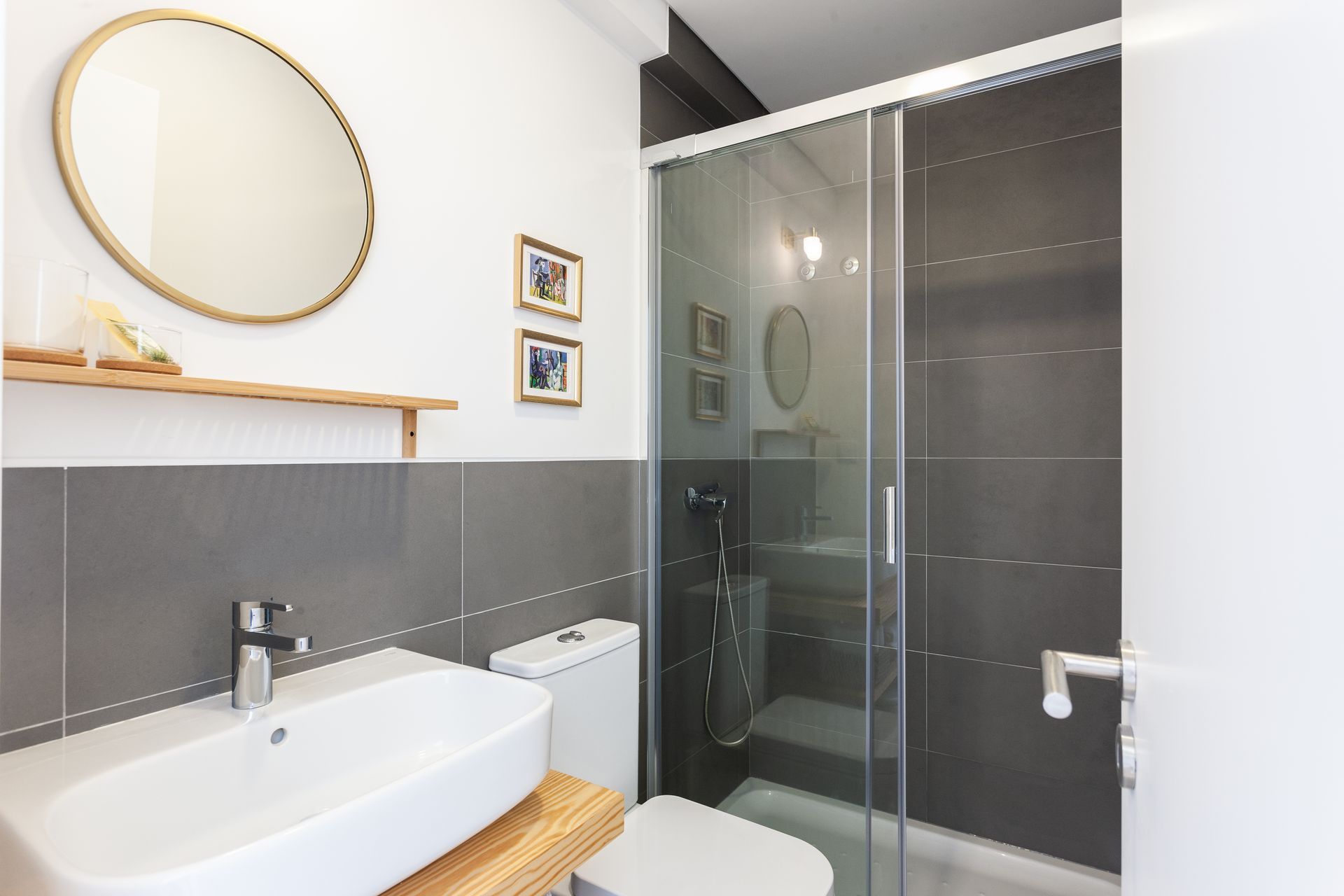 a bathroom with a sink , toilet , mirror and shower stall .