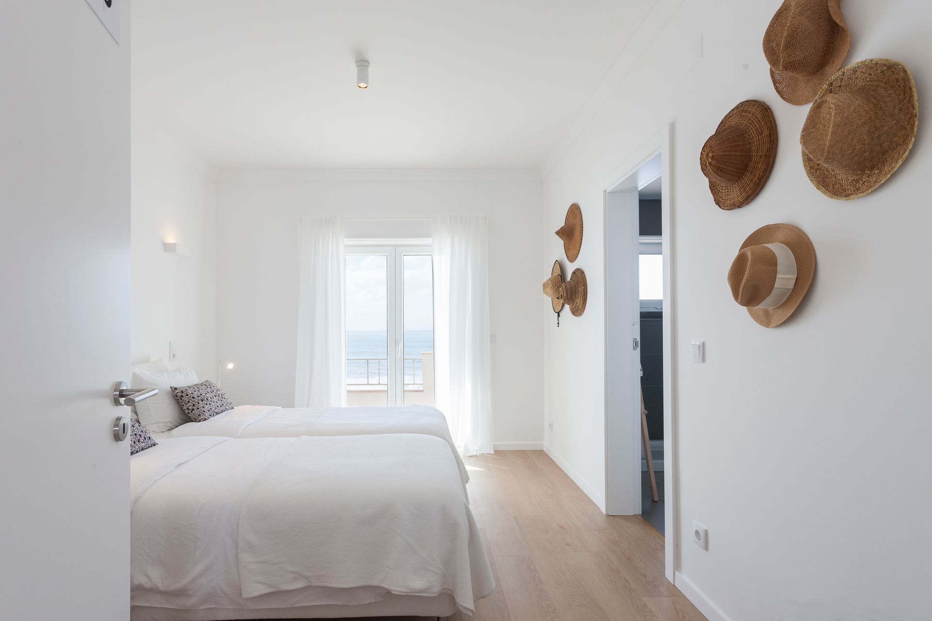 a bedroom with two beds and straw hats hanging on the wall .