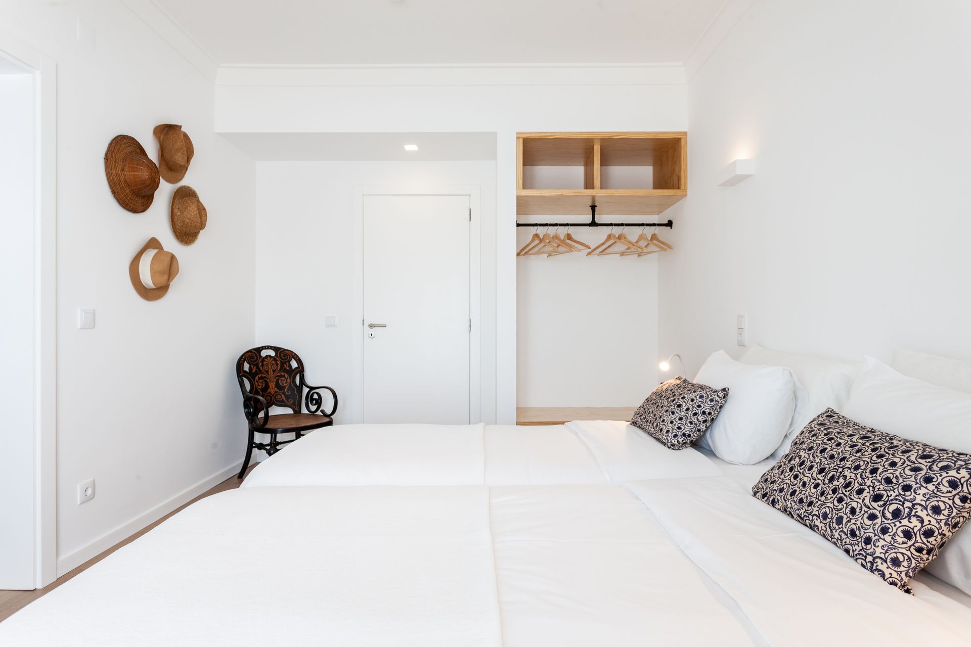 a bedroom with two beds , a chair and a closet .