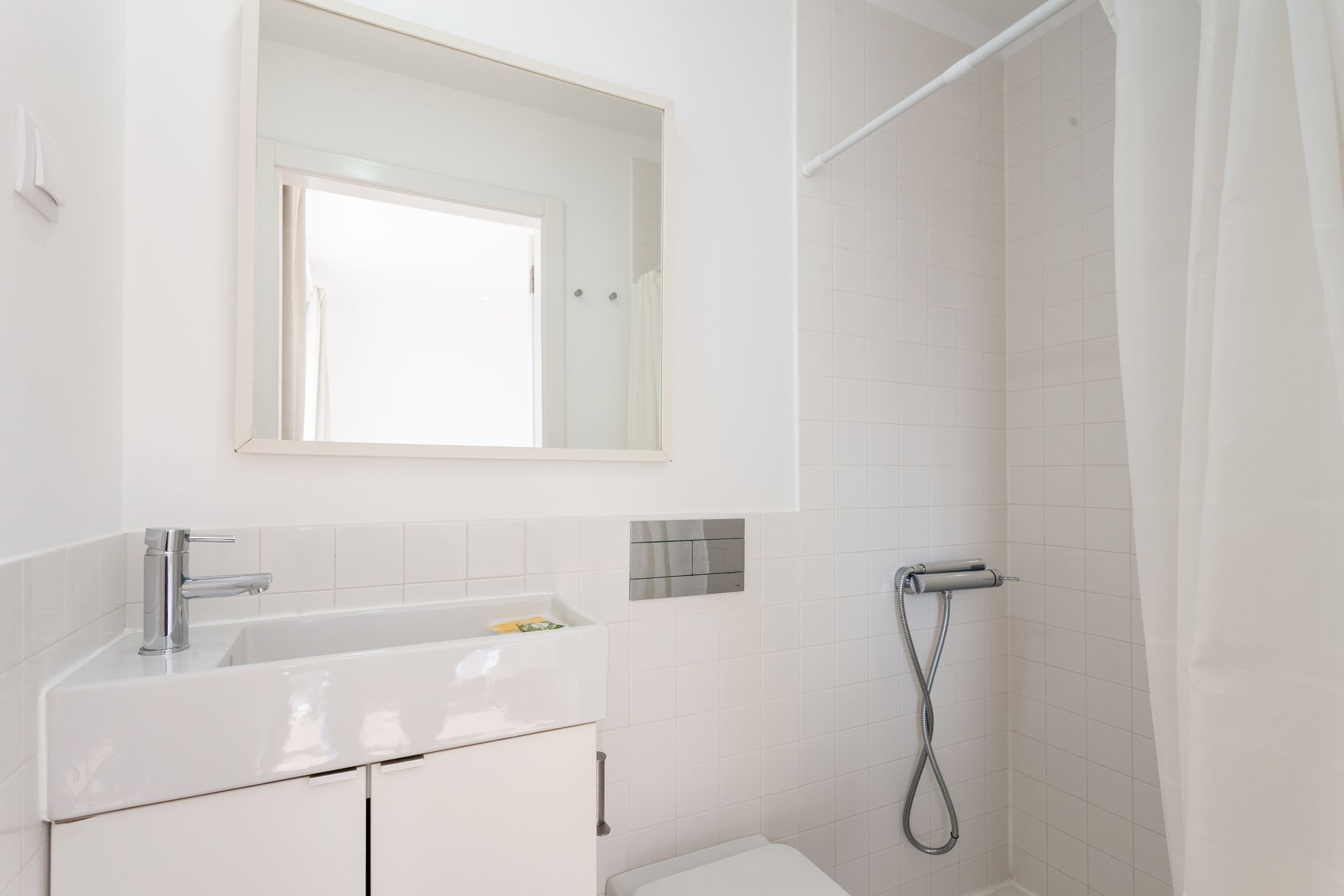 a bathroom with a sink , toilet , shower and mirror .
