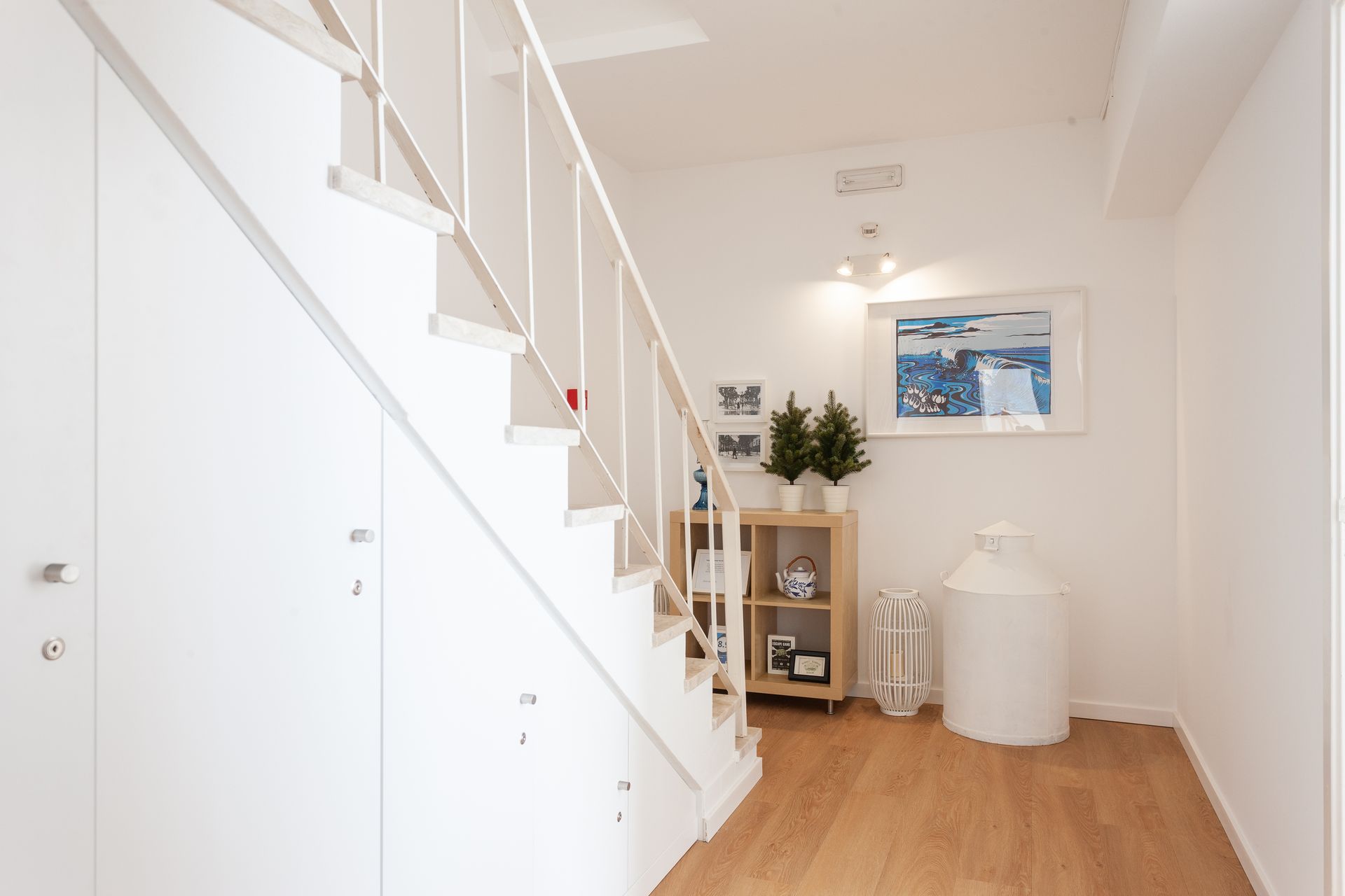 a hallway with stairs and a picture on the wall .