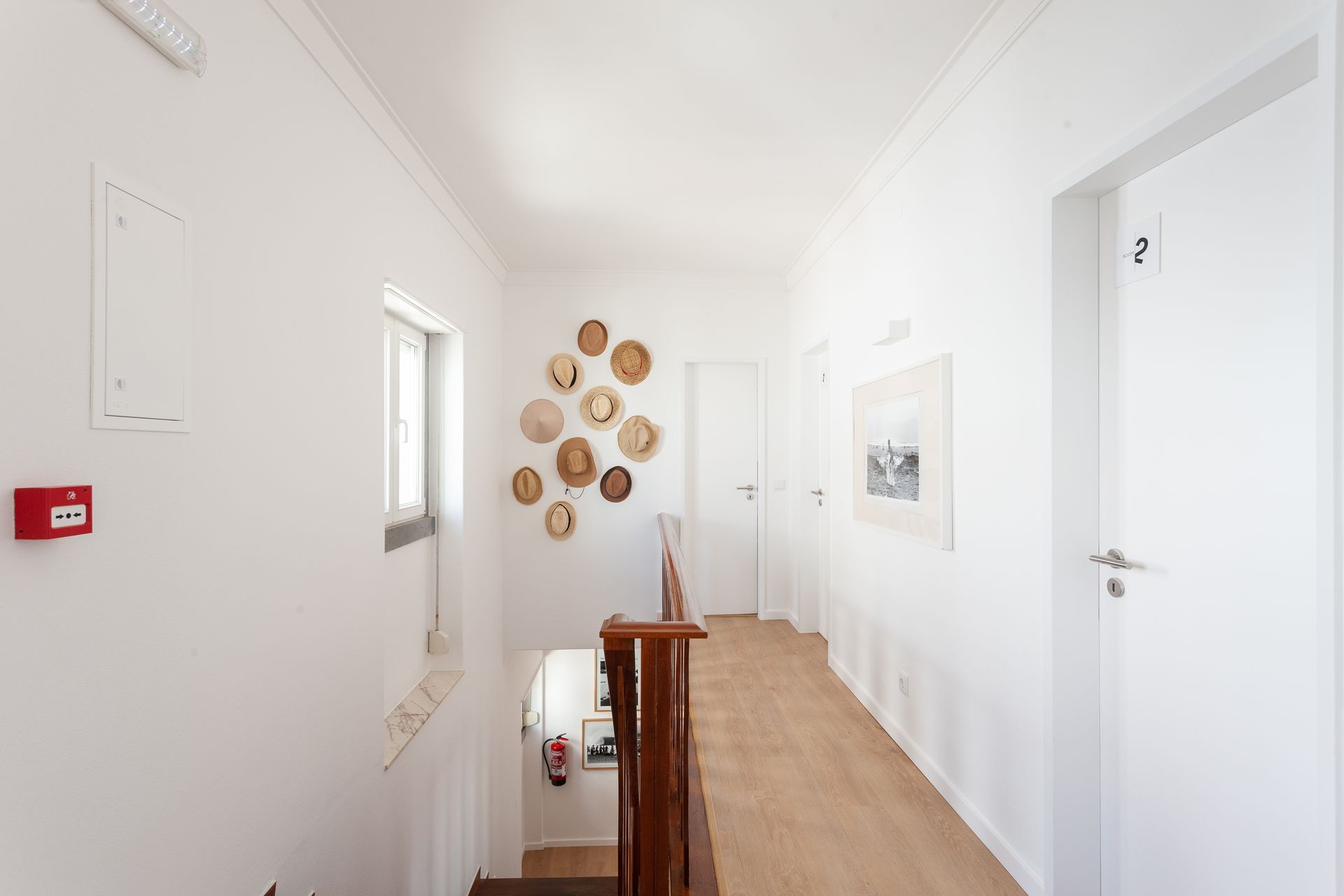 a long hallway with stairs and a fire extinguisher on the wall .