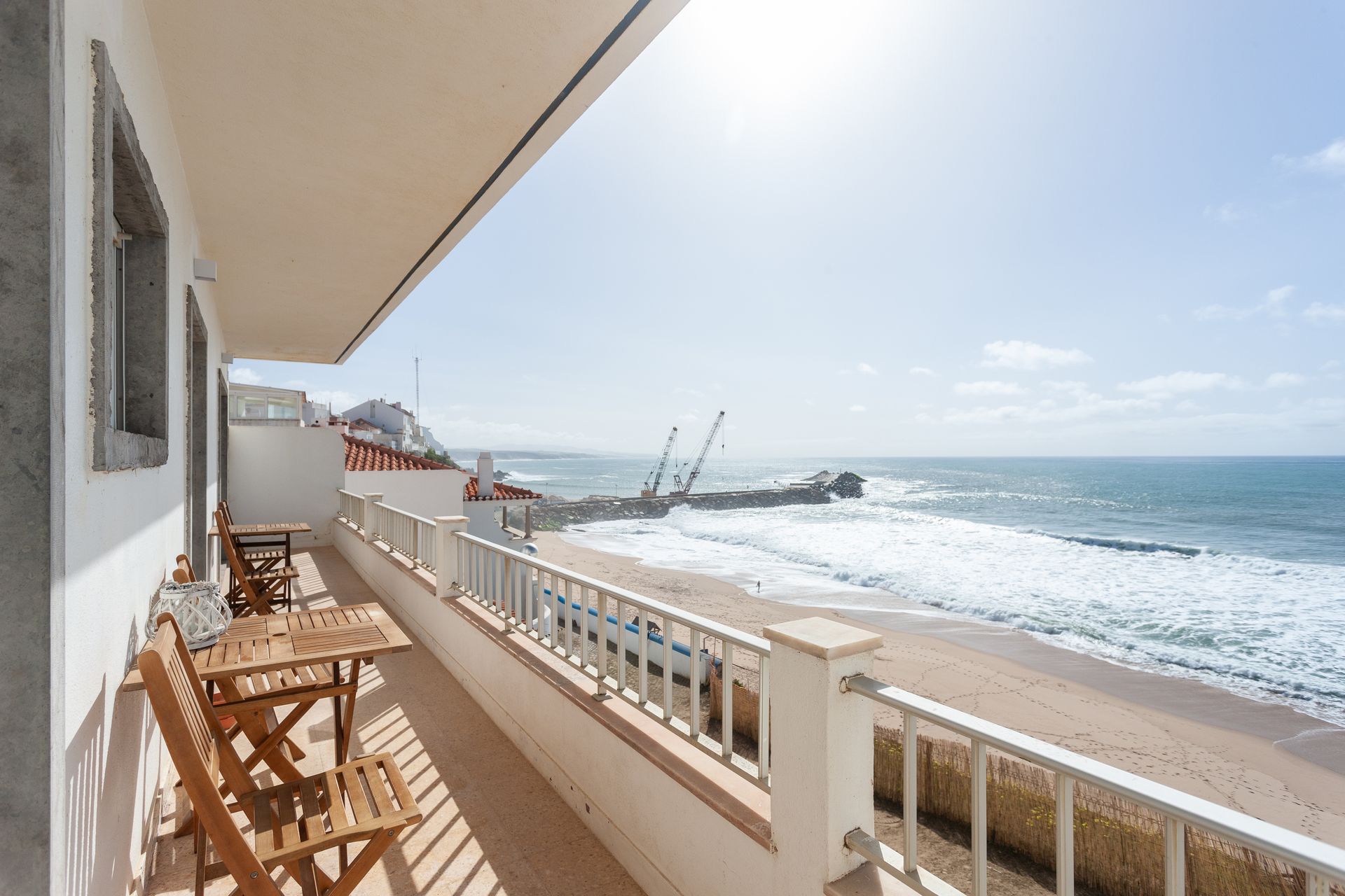 a balcony overlooking the ocean with a table and chairs