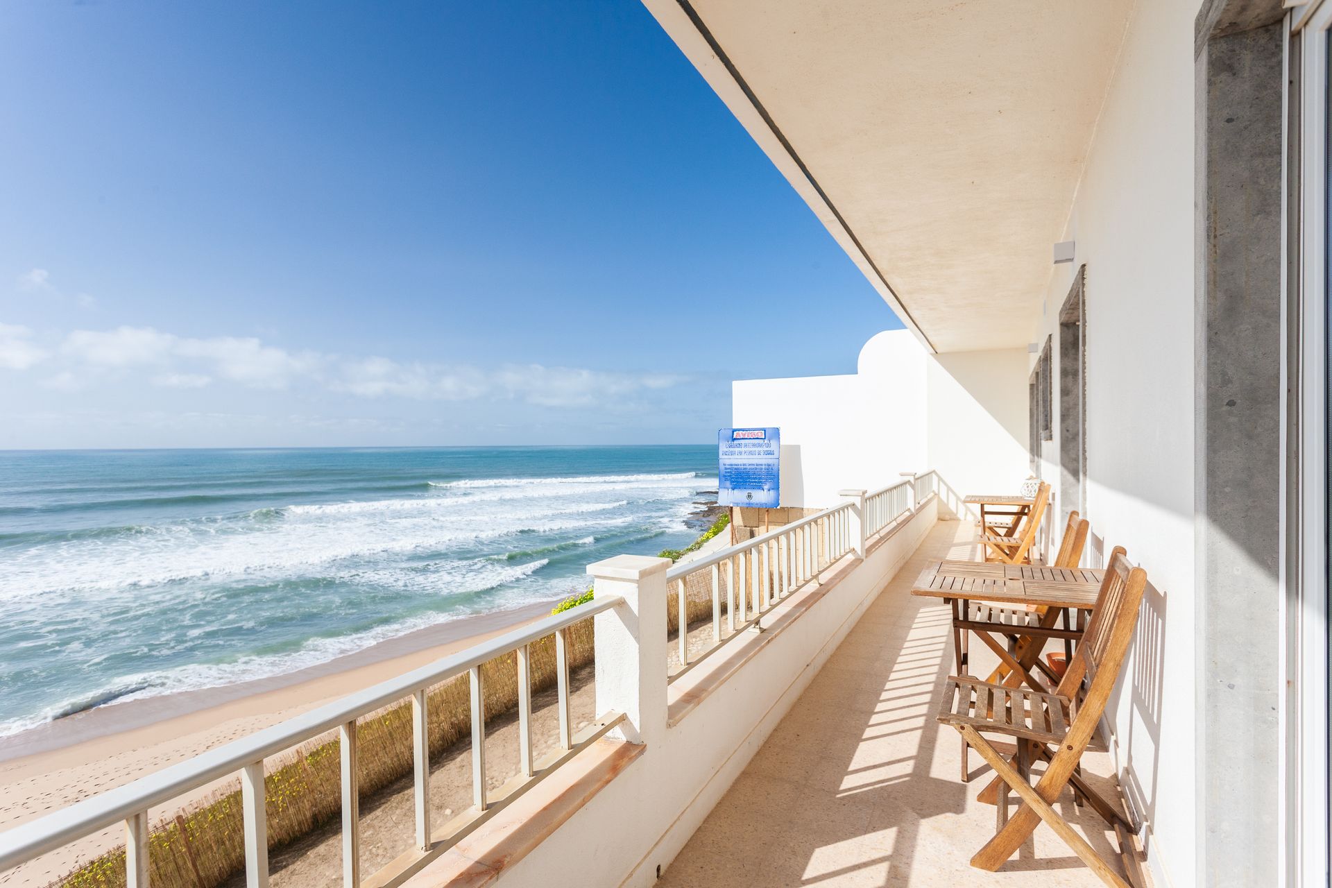a balcony with a table and chairs overlooking the ocean