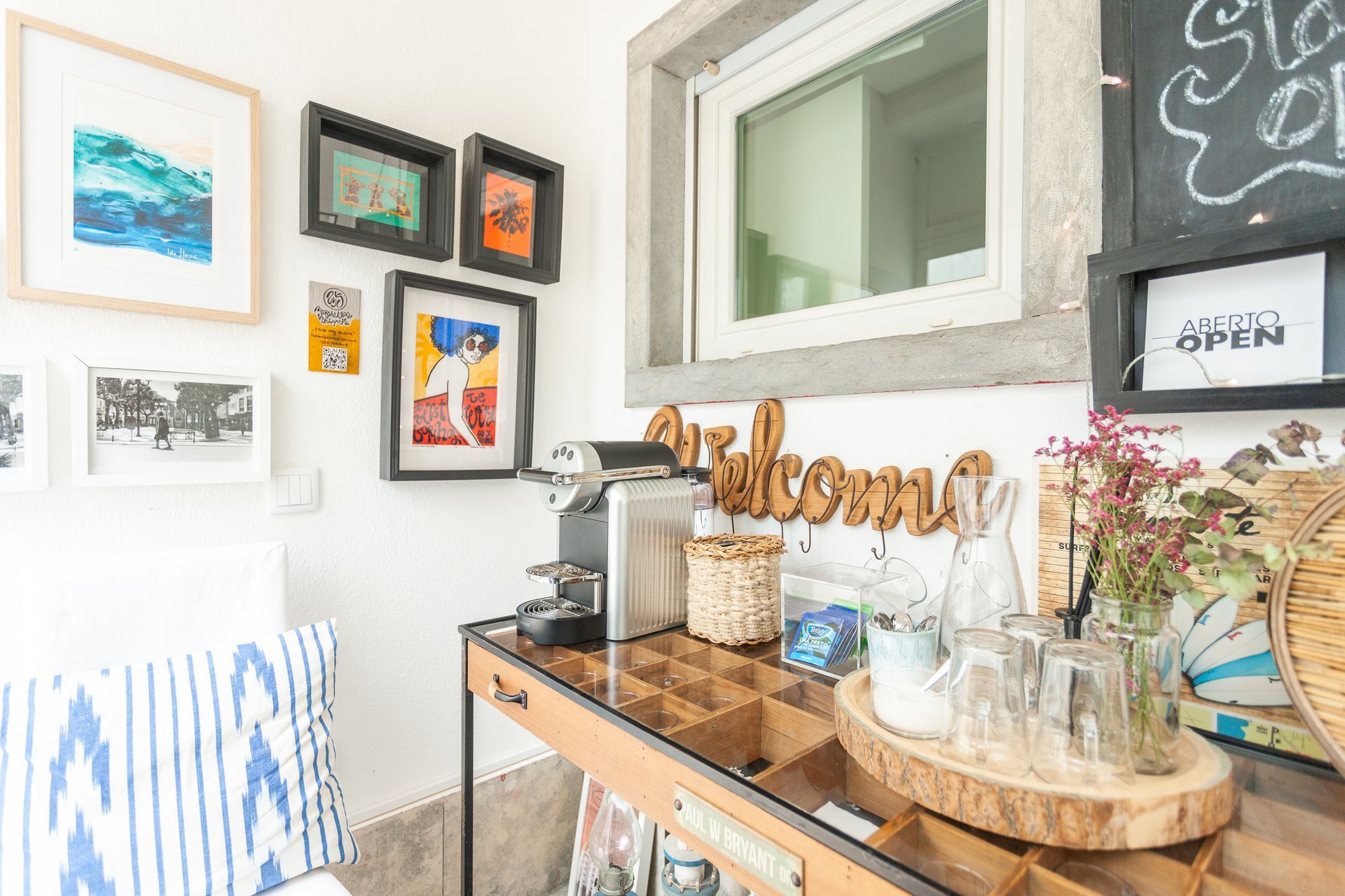 a room with a table and a window with a welcome sign on the wall .