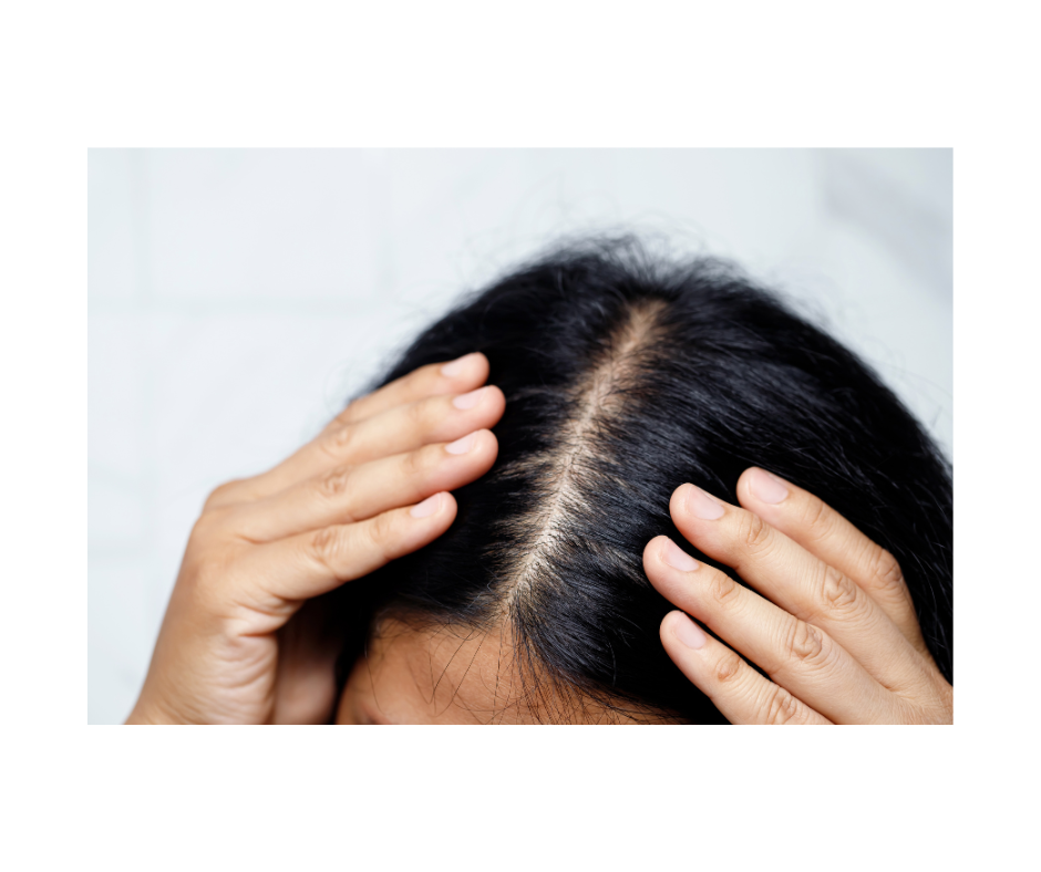 a woman is touching her hair with her hands .