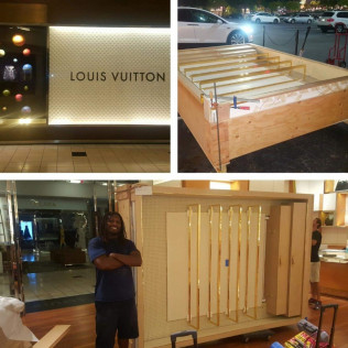 Louis Vuitton store, construction in progress. Man smiles next to a partially built display case.