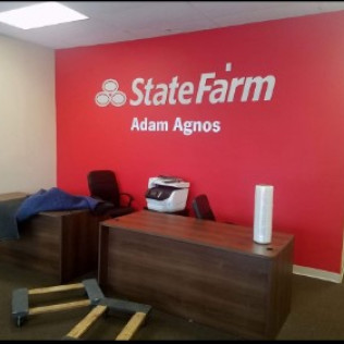 State Farm office interior with red wall, logo, and desk.