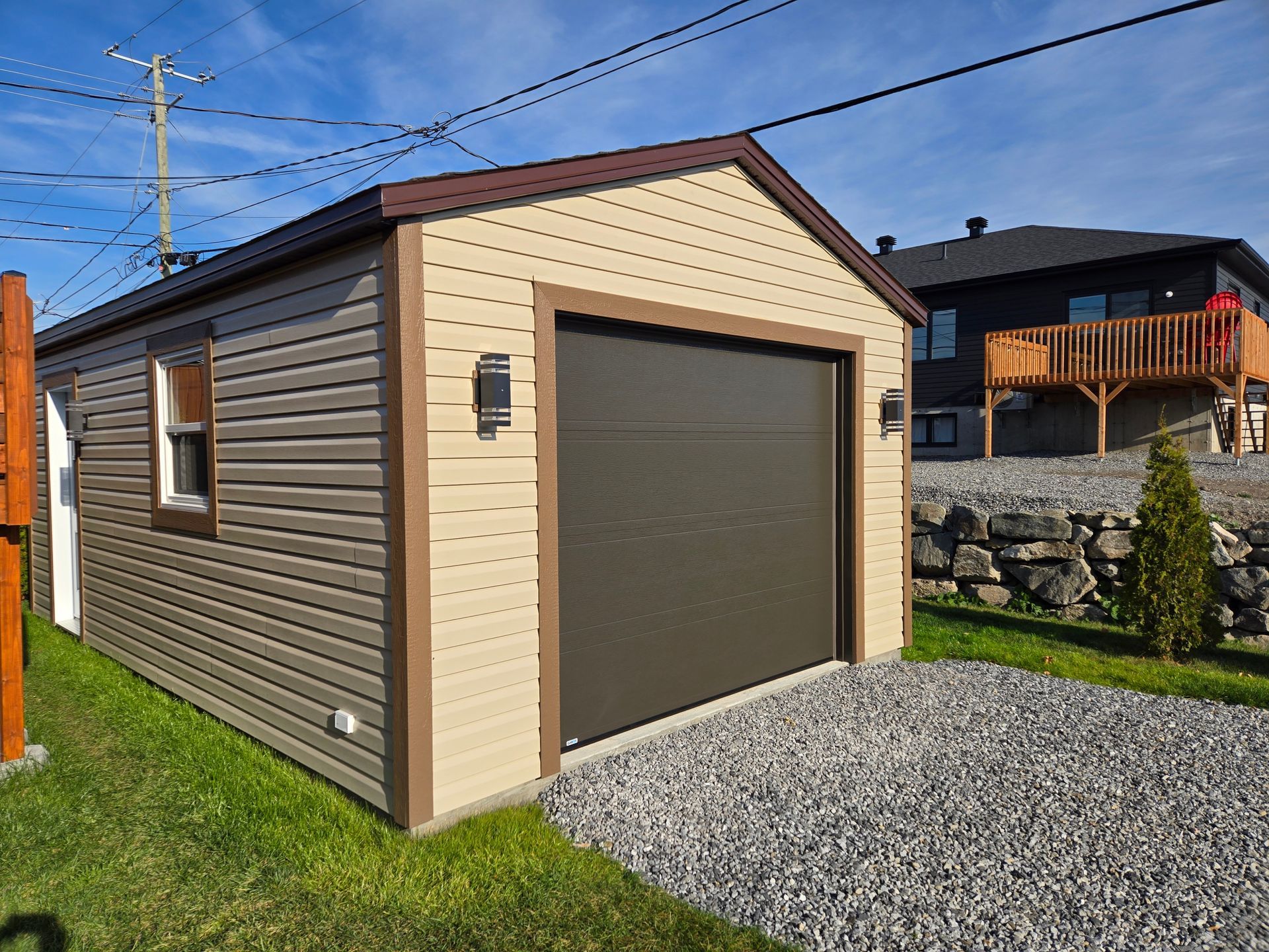 Un garage avec une porte de garage et une maison en arrière-plan.