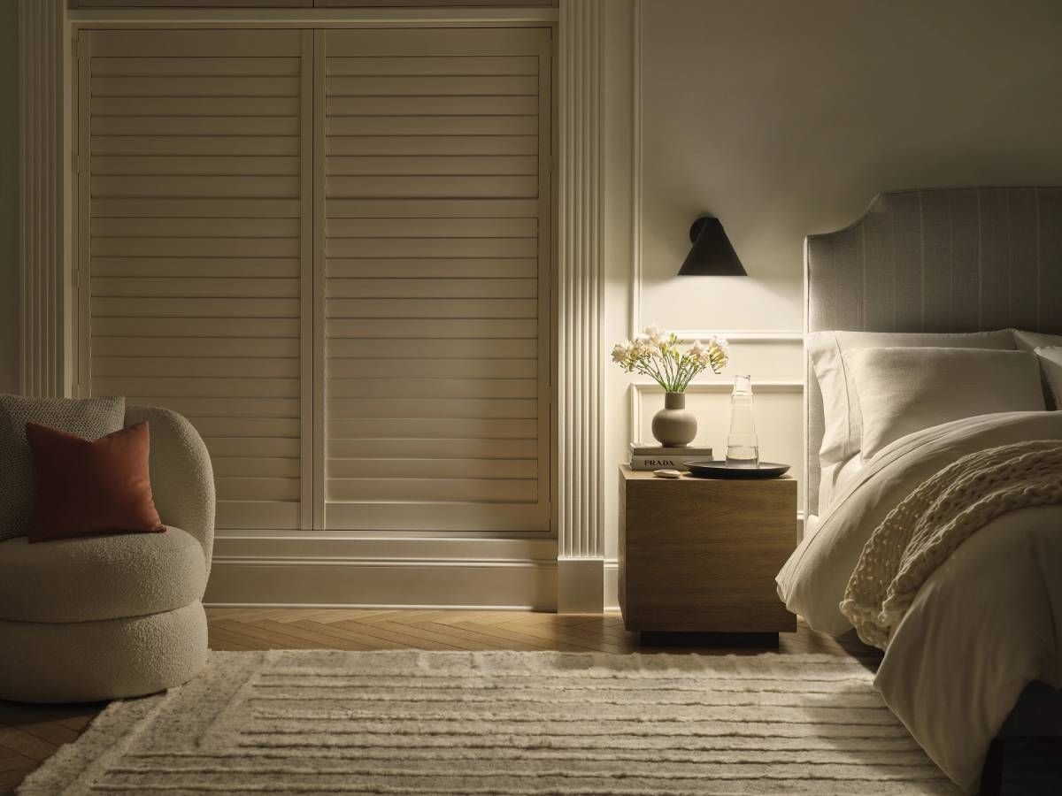Closed Hunter Douglas PalmBeach™ Polysatin™ Vinyl Shutters in a Bedroom Window