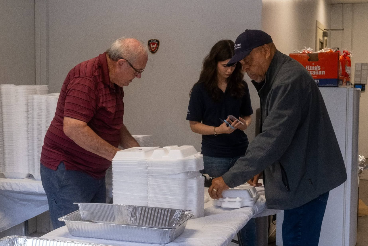 Larry, Jadyn, and Rodney prepping to deliver plates of BBQ to local churches. 