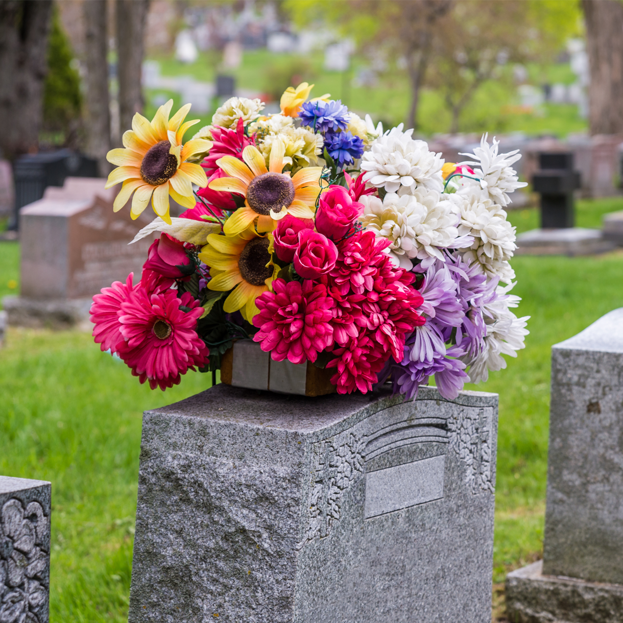 A bouquet of flowers is sitting on top of a grave in a cemetery.