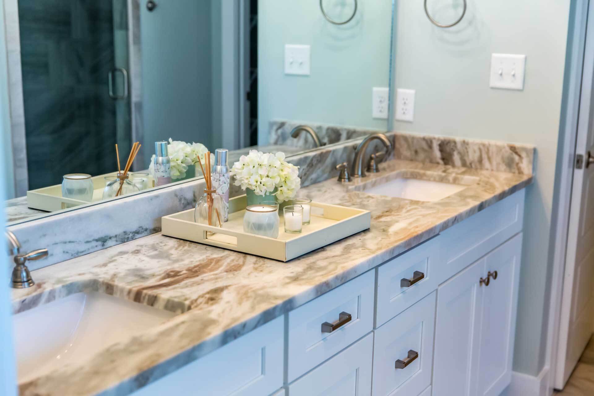 A bathroom with two sinks , a mirror and a tray on the counter.